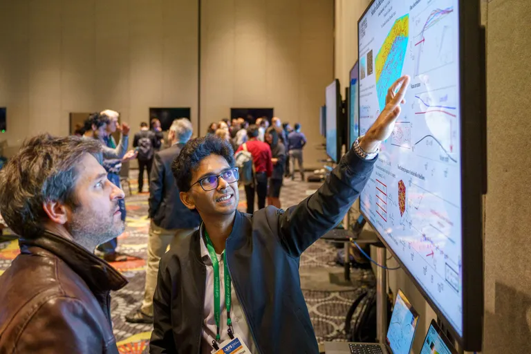 A presenter shows their research to an attendee 